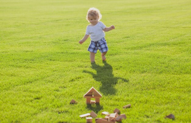 緑の草で保険の子供たちの子供の発達の赤ちゃんの遊び