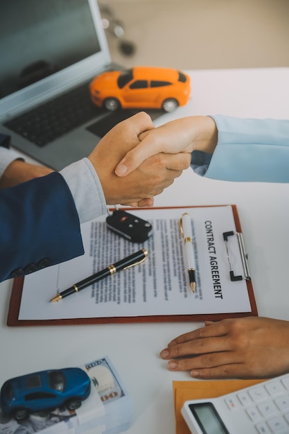 Insurance officers hand over the car keys after the tenant have signed an auto insurance document or a lease or agreement document buying or selling a new or used car with a car