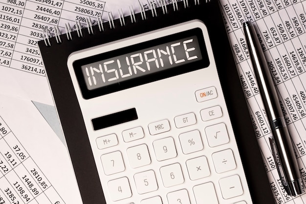 Insurance word on calculator desk with documents with numbers