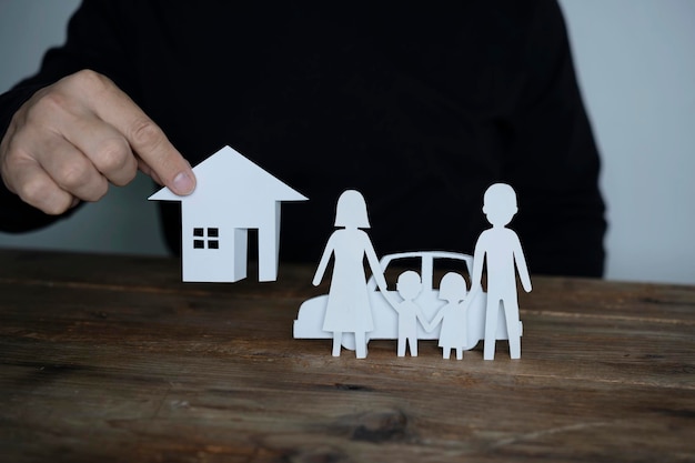 Insurer protecting house family and car with his hands