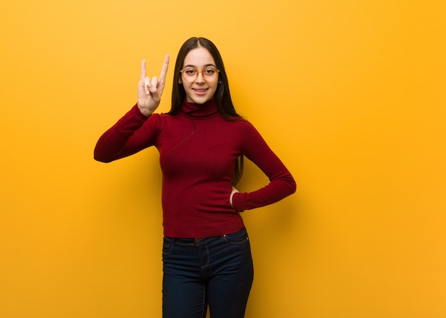 Intellectual young woman doing a rock gesture