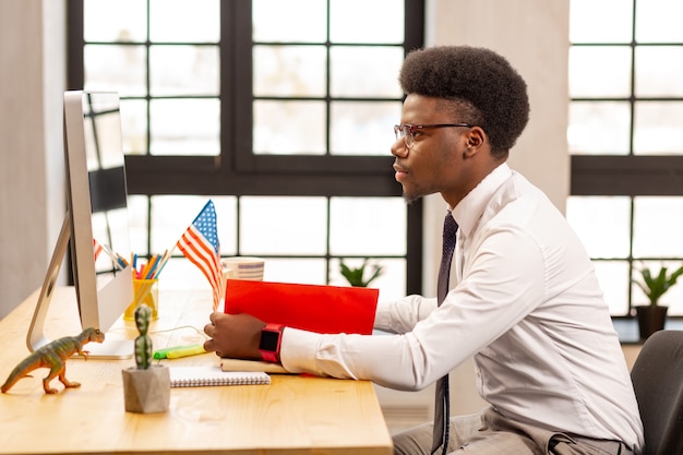  Intelligent young businessman sitting in the office while focusing on his work