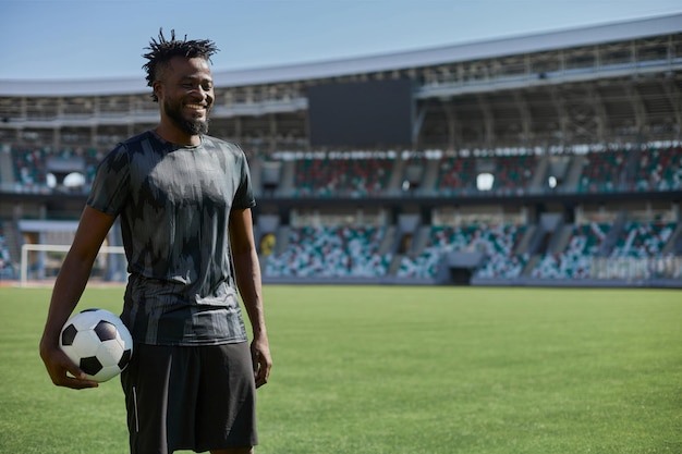 Intense portrait of a football player holding the ball in the stadium