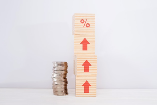 Interest rate financial and mortgage rates concept. wooden cube\
block increasing on top with icon percentage symbol and arrow\
upward direction