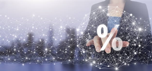 Interest rate, financial, ranking and mortgage rates concept. Hand touch digital screen hologram percent sign on city light blurred background.