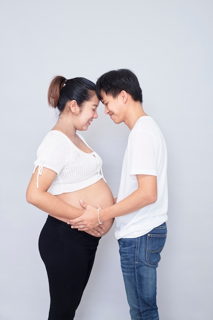 Interesting Asian couple, happy pregnant mother and father isolated on white surface, International family day