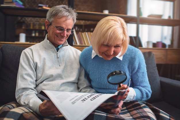 Photo interesting picture of white-haired man and woman sitting on the sofa