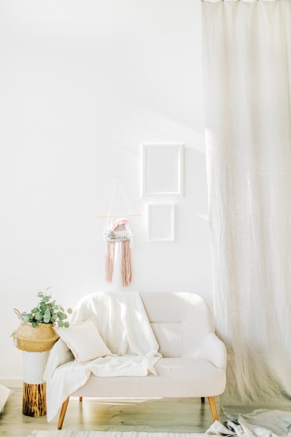 Interieur ontwerpconcept. Lichte kamer met witte muren, eucalyptus in rieten mand, stoel en gordijnen.