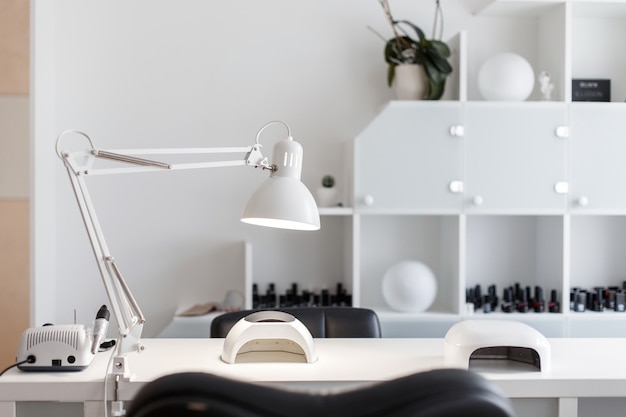 Foto interieur studio voor nagelverzorging. witte kamer voor manicure met een lamp en een gereedschap