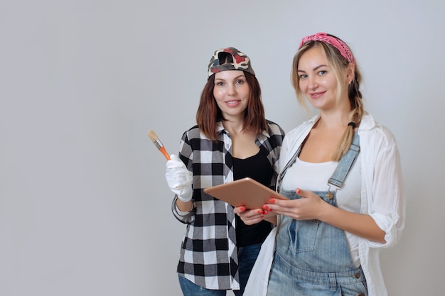 Interieur twee schattige meisjes ontwerper en schilder maken reparaties in het huis een team van decorateurs