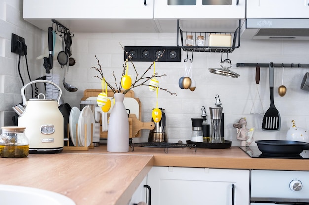 Interieur van de keuken en details van de inrichting van gebruiksvoorwerpen met paasversiering van kleurrijke eieren in een loftstijl feestelijk interieur van een landhuis