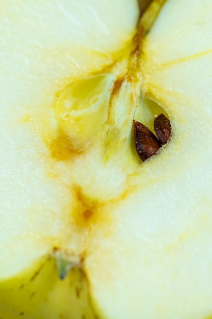 Interieur van een gele appel in tweeën gesneden met zijn zaden die door het midden van de appel macrofotografie gluren
