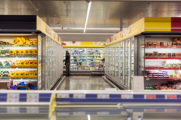 Interieur van een grote supermarkt met glazen vitrines met gekoelde producten.