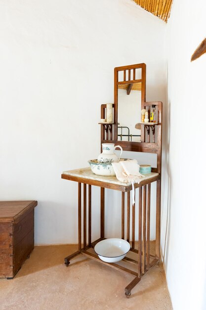 Interieur van een hotelkamer met een houten tafel, stoel en spiegel