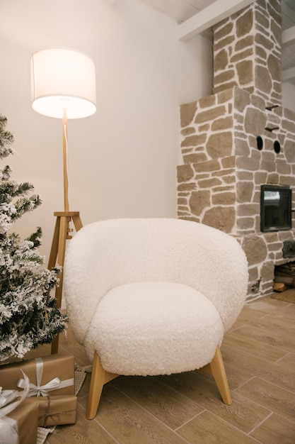 Interieur van een prachtig licht huis ingericht naar nieuwe witte pluche fauteuil vloerlamp en open haard