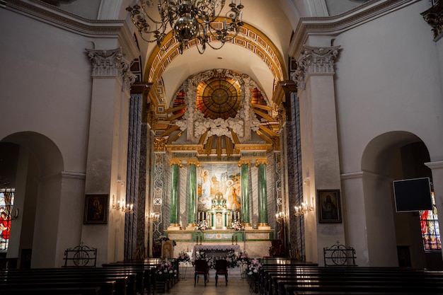 Interieur van een prachtige katholieke kerk met bankpictogrammen en kroonluchters