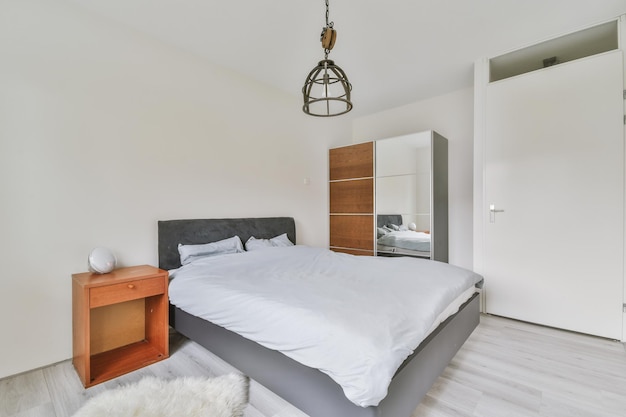 Interieur van een slaapkamer met een klein bed in wit met laminaatvloer in een modern huis