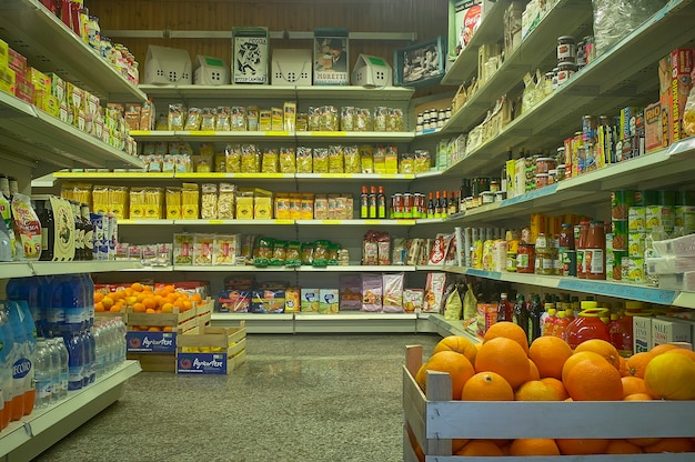 Interieur van een supermarkt met uitzicht op planken vol goederen en boodschappen.