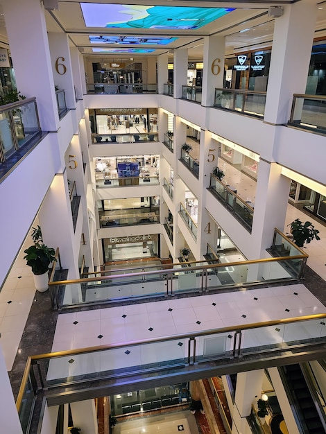 Interieur van een winkelcentrum op meerdere niveaus met roltrappen en uitzicht op het open atrium
