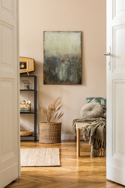 Interieur van een woonkamer in oosterse stijl met moderne chaise longue, plank, rotan mand, retro radio, bloemen en elegante persoonlijke accessoires. schilderijen op de beige muur.