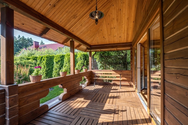 Interieur van lege hal veranda in houten dorp vakantiehuis met tuinstoelen