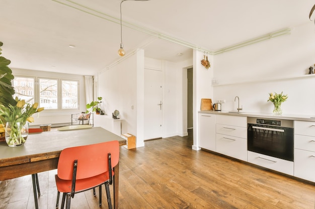Interieur van lichte keuken en eetkamer met ramen en planten in modern appartement overdag
