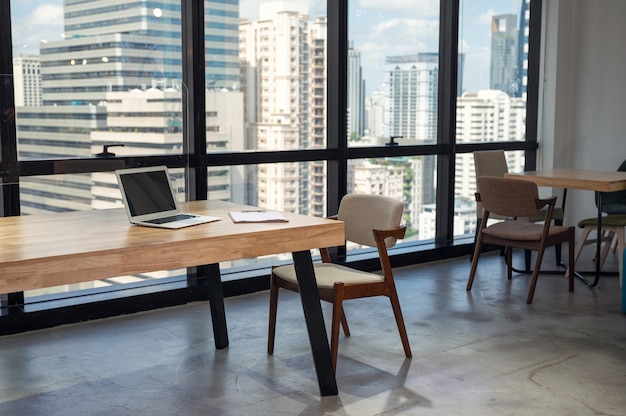 Interieur van niemand modern kantoor met laptop, klembord op houten bureau en stoel in het district busuness