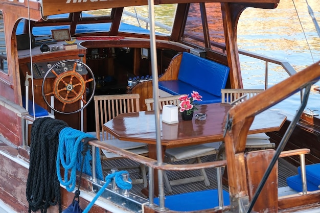 Interieur van vintage jacht, houten stuurwiel en tafel met stoelen