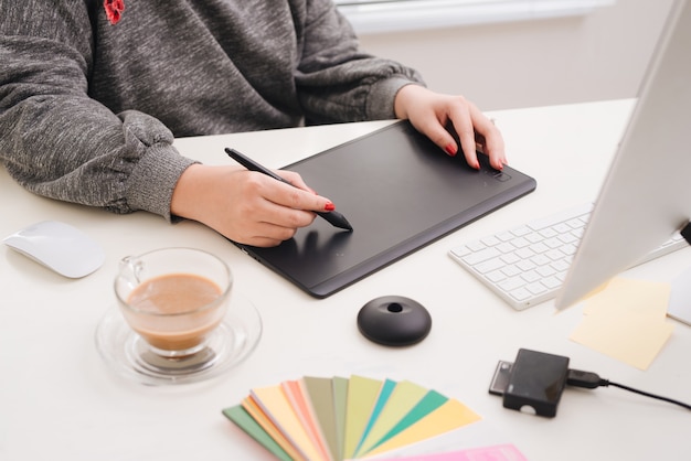 Interieurontwerperhand die met nieuwe moderne computerlaptop en pro digitale tablet werkt