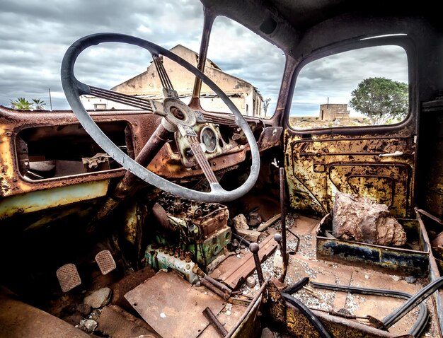 Foto interno di un'auto abbandonata contro il cielo