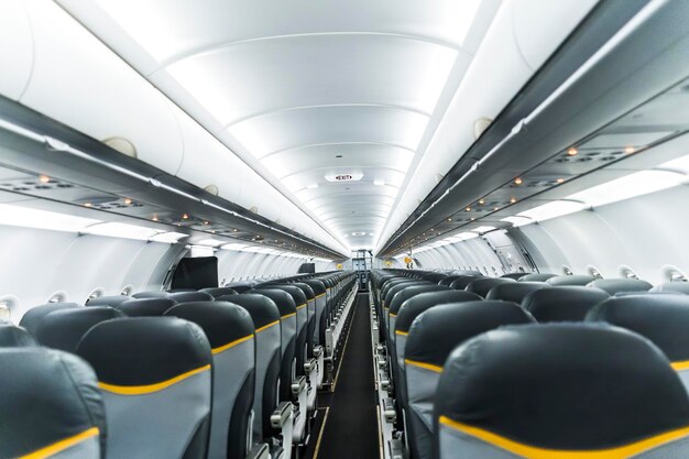 Interno dell'aereo senza passeggeri sui sedili. concetto di trasporto. l'interno del corridoio dell'aeromobile in toni moderni. messa a fuoco selettiva.