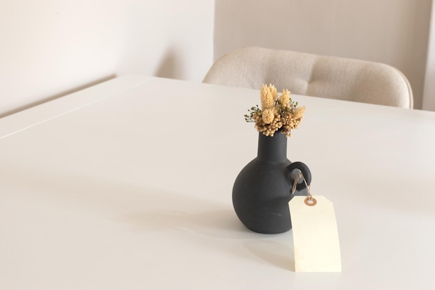 Interior background of modern empty room with white wall black vase with dry flower and wooden table copy space