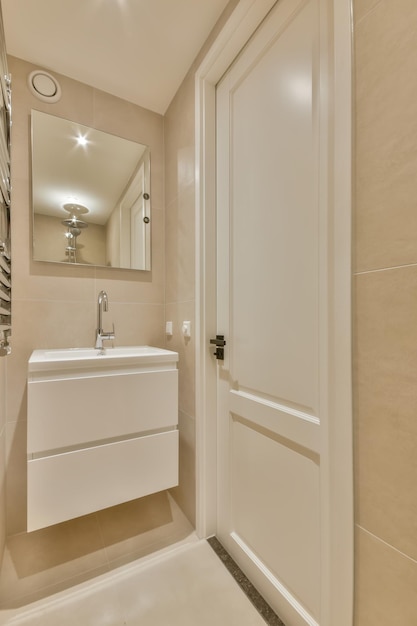 The interior of a bathroom lined with beige tiles i