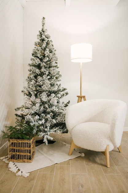 Интерьер красивого светлого дома, украшенного к Новому году елкой белым креслом торшером
