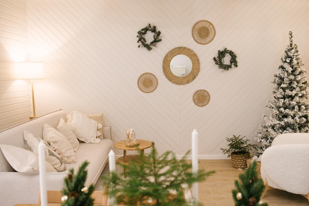 Interior of a beautiful light house decorated for New white sofa armchair and Christmas table