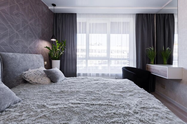 작은 아파트에 현대적인 스타일의 대형 더블 침대가 있는 침실 인테리어