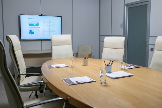 Interior of boardroom with large table surrounded by armchairs