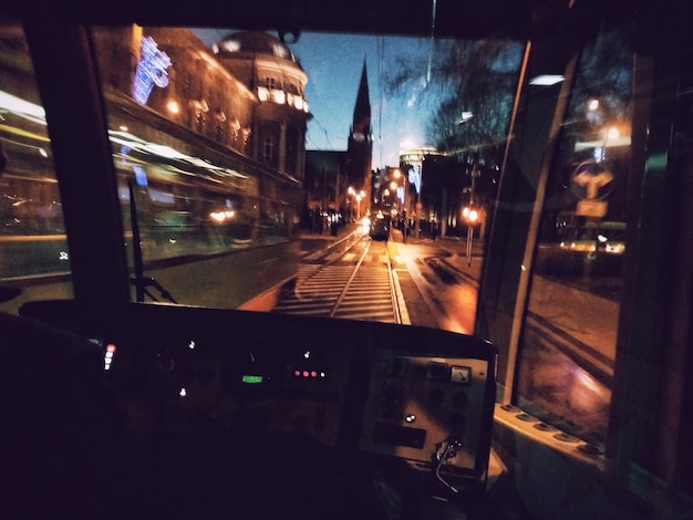 Interior of cable car on road in illuminated city at dusk