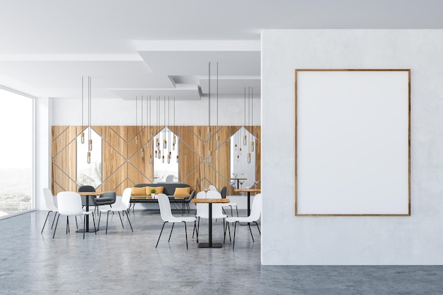 木と白の壁、パノラマの窓、コーヒーテーブルの近くに灰色のソファと肘掛け椅子、正方形のテーブルの近くに白い椅子を持つカフェのインテリア。壁に貼られた縦型ポスター。 3D レンダリングのモックアップ