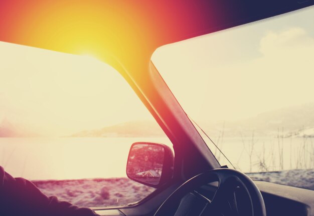 Photo interior of car by lake during sunset