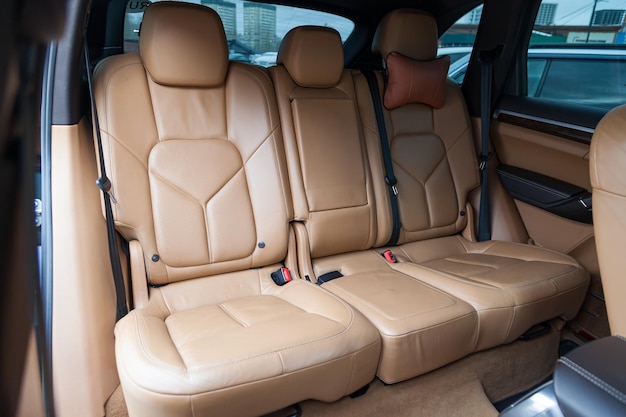 The interior of the car with a view of the rear seats with light brown leather trim