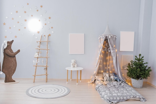 The interior of the childrens room decorated for Christmas Awning with lights and pillows a tree