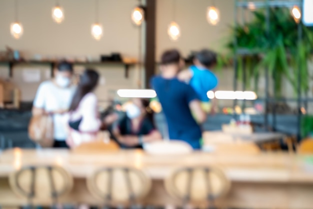 Photo interior of coffee shop with customers using digital devices blurred for back ground