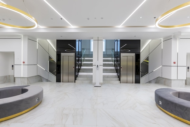 Интерьер современного коридора холла бизнес-центра в белой плитке с мрамором