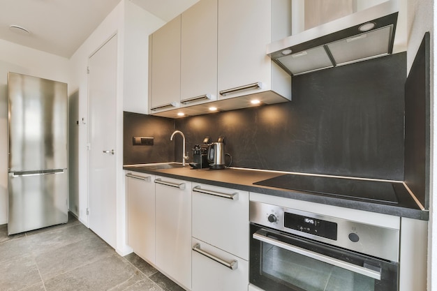 The interior of a corner kitchen in a minimalist style with modern appliances in a cozy residential apartment