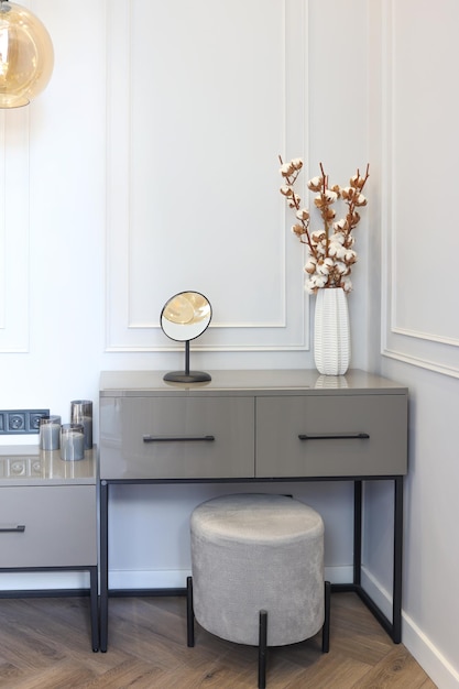 Interior of a cozy feminine home office with laptop mockup eucalyptus plant in vase glasses coffee cup phone and frames Styled blogger's workplace