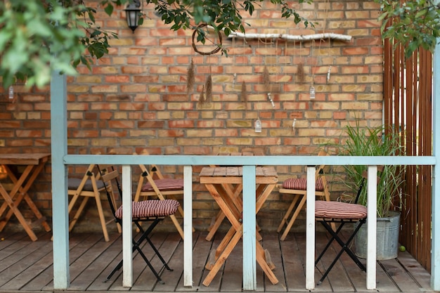 Interior cozy space in patio with wooden table and chairs for relax in backyard.