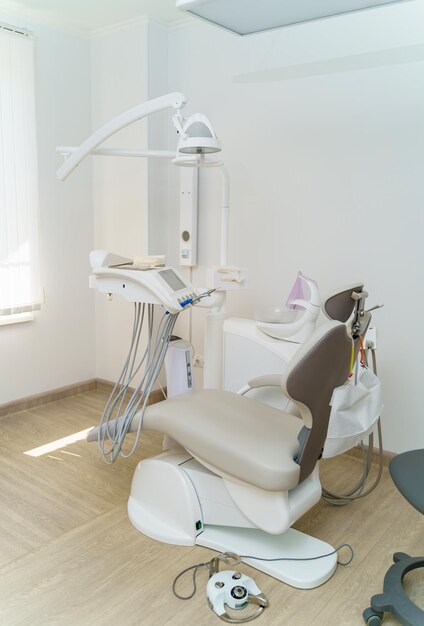 Interior of dental clinic with dental chair dental tools and\
dental lighting equipment oral care concept