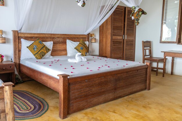 Дизайн интерьера декор меблировка роскошного шоу дома вилла для отдыха спальня с кроватью с балдахином Дизайн интерьера тропической виллы на берегу моря на острове Занзибар Танзания Африка