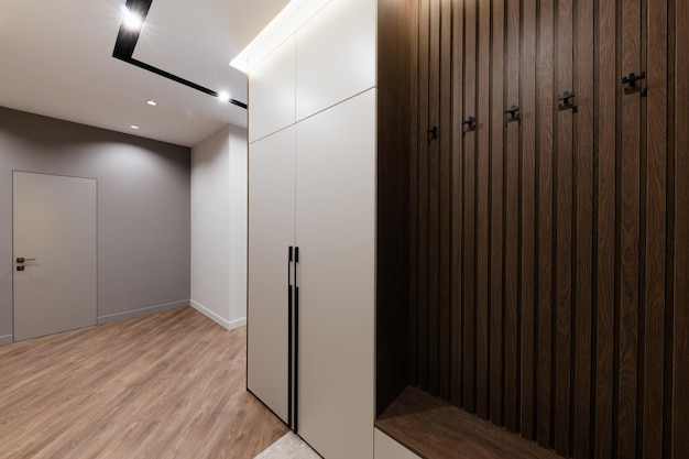 Interior design of a hallway with a white cabinet and a hanger\
made of wood
